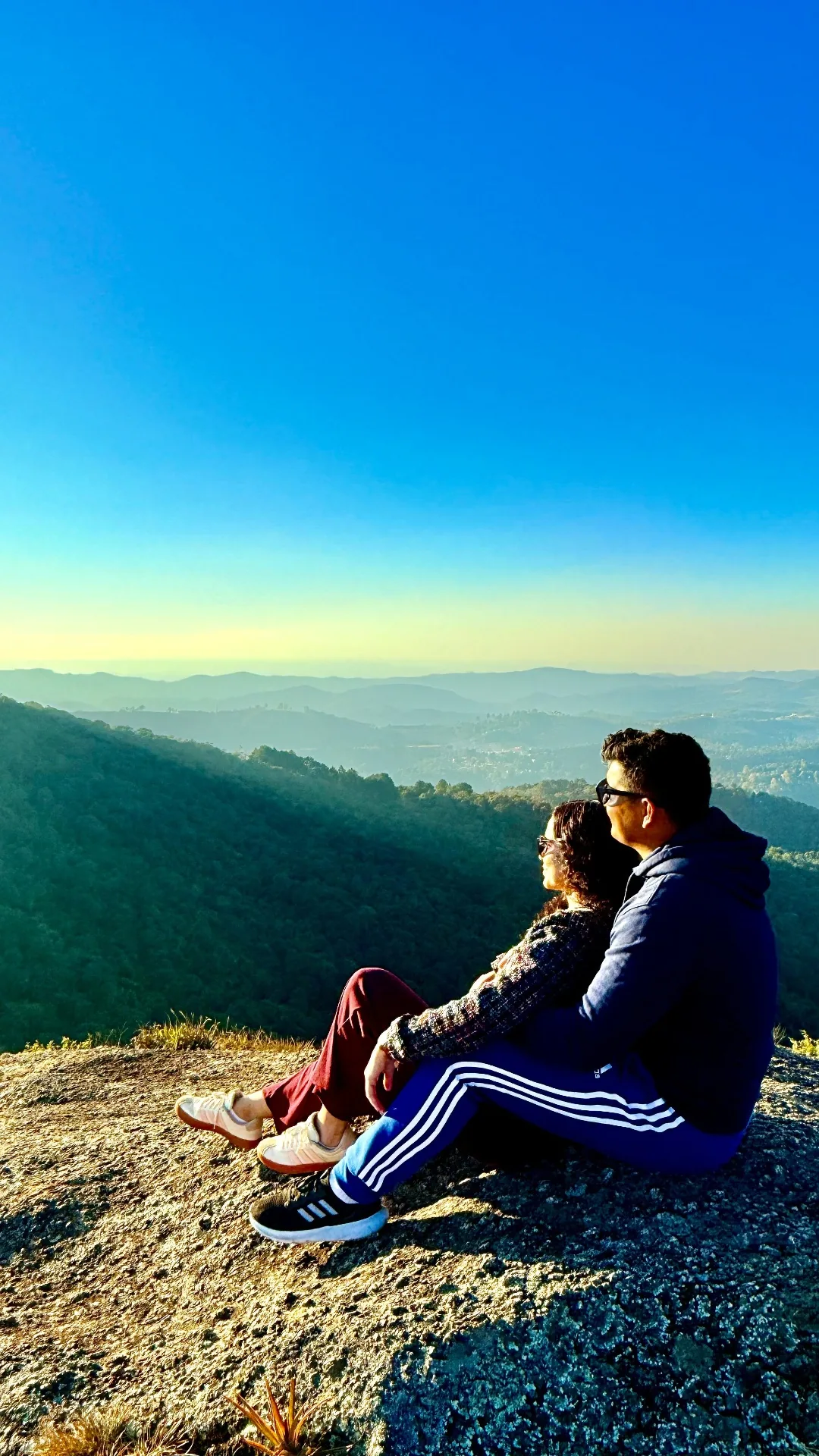 Casal romântico contemplando o pôr do sol na Pedra Redonda