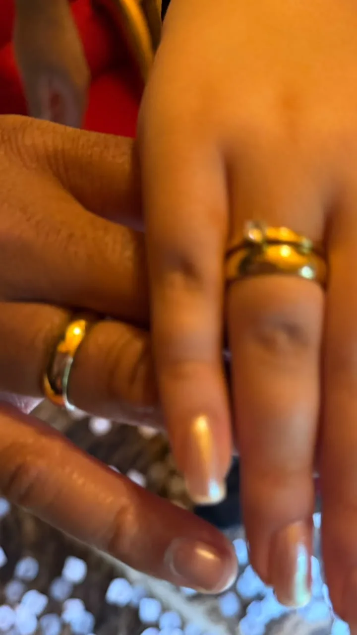Mãos do casal com as alianças logo após o sim, em Monte Verde